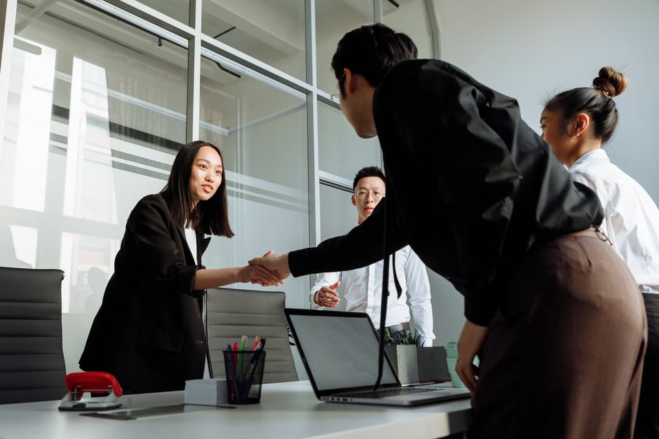 Group of business colleagues shaking hands during an office meeting.